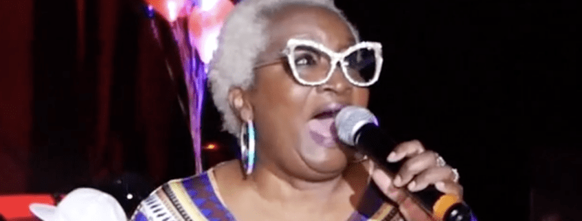 Singer performing with microphone on stage.